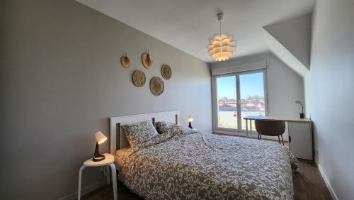 a bedroom with a bed and a window and a table at Le clos des Boucaniers in Berck-sur-Mer