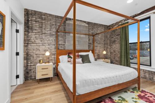 a bedroom with a canopy bed and a brick wall at Grand Rapids Whole Building Rental in Grand Rapids