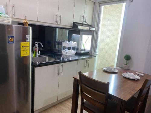 a kitchen with a table and a stainless steel refrigerator at condotel anuva in Manila