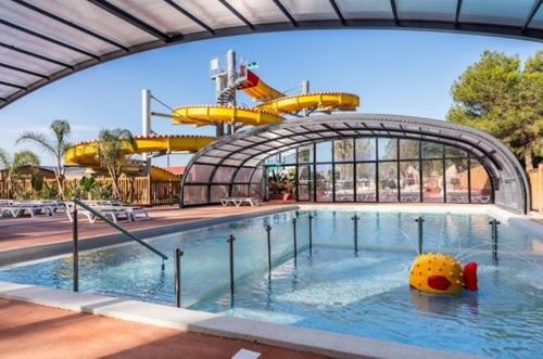 une grande piscine avec une promenade en arrière-plan dans l'établissement MOBIL HOME 4 à 6 PERS Le Canet en Roussillon, à Canet