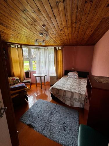 a bedroom with a bed and a wooden ceiling at Vasaras mājiņa pie Rāznas ezera Nr 3 in Kaunata