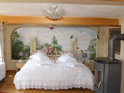 a bedroom with a large bed with a painting on the wall at Pension Rhöner Kräuterwerk 