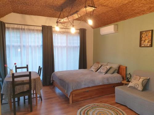 um quarto com uma cama, uma mesa e um sofá em Pūču māja/Owl house namiņš Ogrē em Ogre
