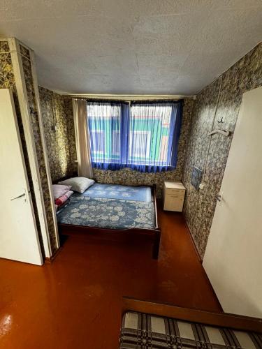Kleines Zimmer mit einem Bett und einem Fenster in der Unterkunft Vasaras mājiņa Nr.6 