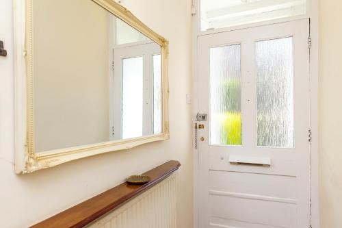 a mirror on a wall next to a door at 2-Bedroom Stunning, Chic, Spacious & Stylish Retreat, Central Winchester, Free On-Street Parking, Sleeps 6, Pet-Friendly - by Blue Puffin Stays in Winchester