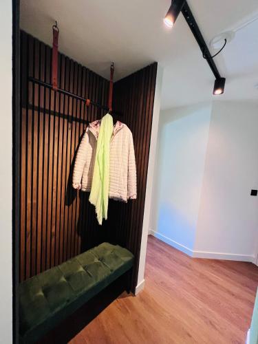 a room with a wooden wall with a green bench at Garden Street Lommel - The Green Haven in Lommel