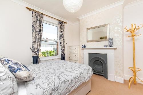 a bedroom with a bed and a fireplace at 2-Bedroom Stunning, Chic, Spacious & Stylish Retreat, Central Winchester, Free On-Street Parking, Sleeps 6, Pet-Friendly - by Blue Puffin Stays in Winchester