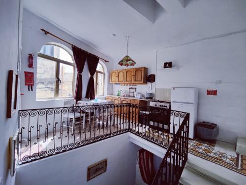 eine Küche mit einer Treppe, die zu einer Küche mit einem Kühlschrank führt in der Unterkunft Traditional Maltese Townhouse in Rabat in Rabat