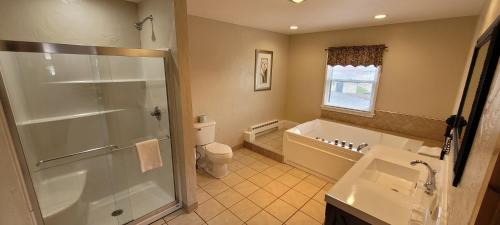 a bathroom with a shower and a toilet and a sink at Pictured Rocks Inn and Suites in Munising