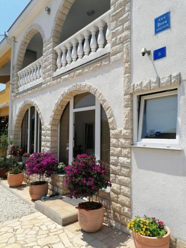 a building with potted plants in front of it at Apartment Megy in Vir