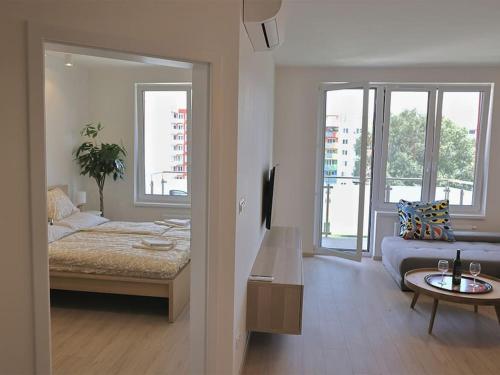 Schlafzimmer mit einem Bett, einem Tisch und Fenstern in der Unterkunft Luxury 2 Room Apartment nr. 4 in Bratislava
