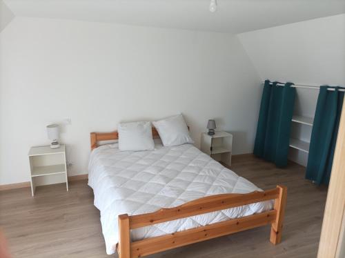 una camera con letto in legno e tende blu di Gîte de saint pabut a Pluherlin