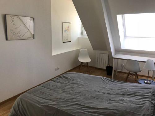 1 Schlafzimmer mit einem Bett, einem Fenster und 2 Stühlen in der Unterkunft Le duplex de Talleyrand Hyper Centre in Reims