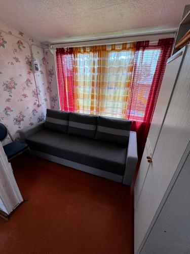 a room with a couch in a room with a window at Vasaras mājiņa pie Rāznas ezera Nr 7 in Ragi