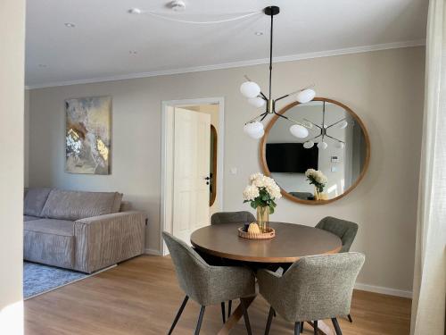 a dining room with a table and a mirror at My Baltic Sea - Ferienwohnungen im Ocean Hill in Scharbeutz