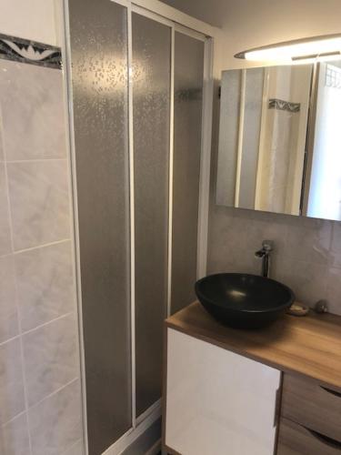 La salle de bains est pourvue d'un lavabo noir et d'une douche. dans l'établissement Appartement cosy dans une résidence avec piscine, à Cavalaire-sur-Mer