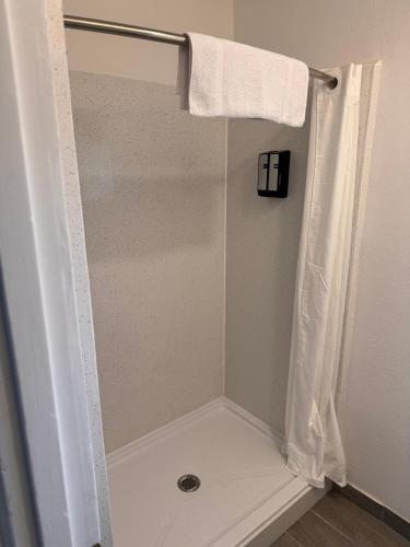 a shower with a white shower curtain in a bathroom at The Lodge Tulelake in Tulelake
