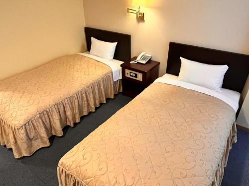 Hotel Sho Sapporo - Vacation STAY 61073v في سابورو: غرفه فندقيه سريرين وتلفون