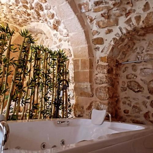 uma casa de banho com uma banheira numa parede de pedra em ARev BUTİK HOTEL em Mardin