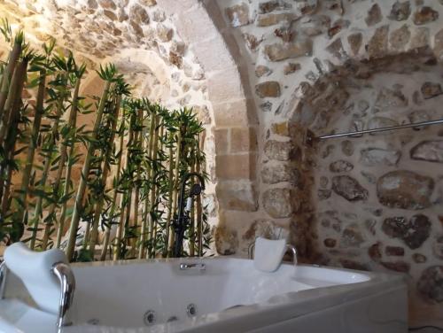 baño con bañera blanca en una pared de piedra en ARev BUTİK HOTEL, en Mardin