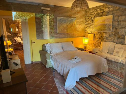 Neviano degli ArduiniにあるVilla Chiccaのベッドルーム(大型ベッド1台、ソファ付)