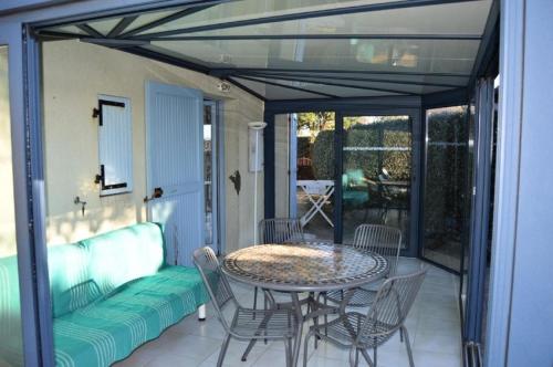 een patio met een tafel en stoelen en een bank bij Résidence ILE DES PECHEURS - Maisons & Villas pour 6 Personnes 34 in Port Leucate