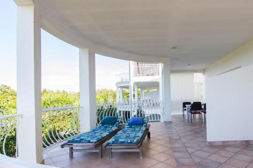 a porch with benches and chairs on a balcony at Wish Apartments in Poreč
