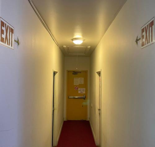 a hallway with a yellow door and a red carpet at HOLLYWOOD HIGHLAND HOTEL AND HOSTEL in Los Angeles