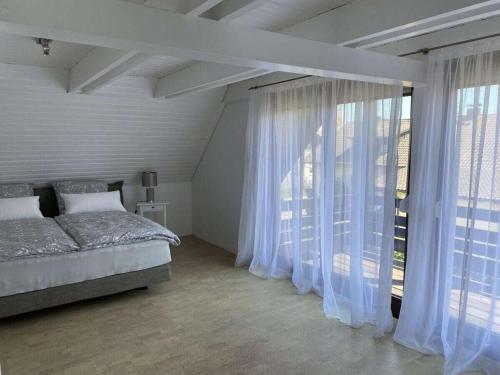 ein Schlafzimmer mit einem Bett und einem großen Fenster in der Unterkunft Amazing apartment in Baden-Württemberg in Owingen