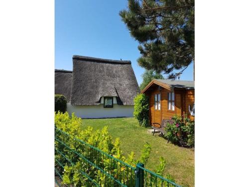 een huisje met een rieten dak en een tuin bij Holiday home thatched roof house in Großenbrode