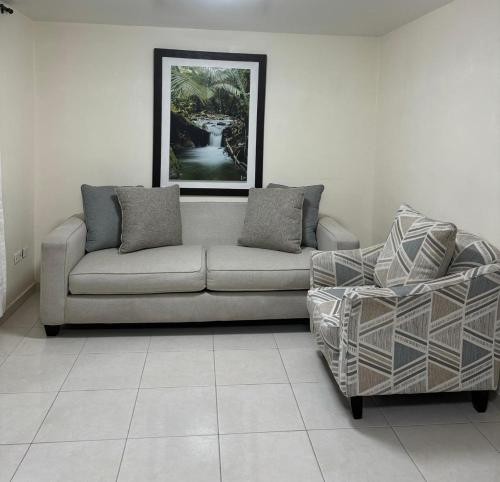 - un salon avec un canapé et une chaise dans l'établissement Espectacular casa vacacional con garaje en Pereira, à Pereira