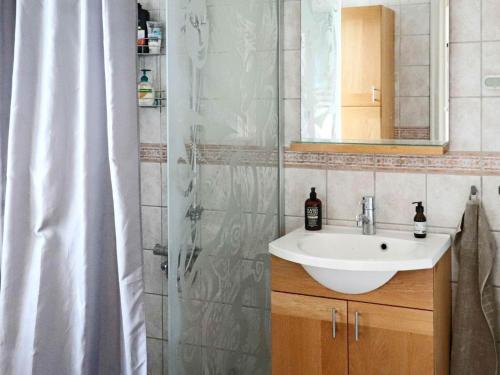 a bathroom with a sink and a shower curtain at Holiday home Halmstad XII in Halmstad