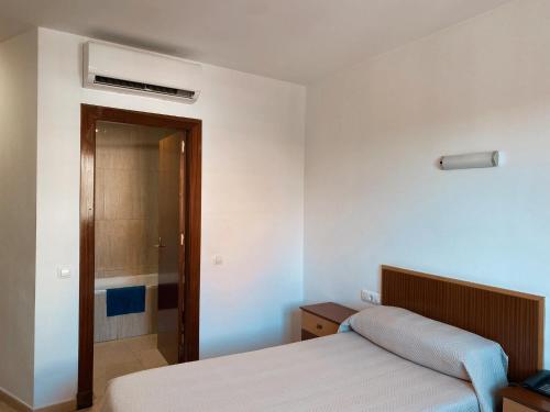 a bedroom with a bed and a door to a bathroom at Pensión Torrecárdenas in Almería