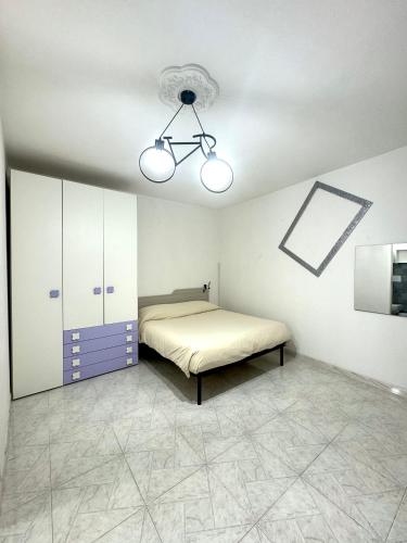 ein Schlafzimmer mit einem Bett und einer Decke in der Unterkunft Monolocale Romeo in Locri