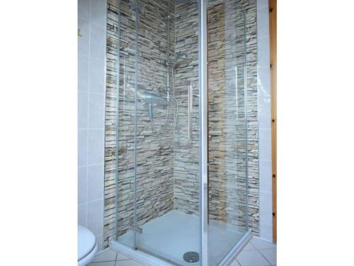 a shower with a glass door in a bathroom at Beach holiday home directly on the Veluwemeer in Kargow