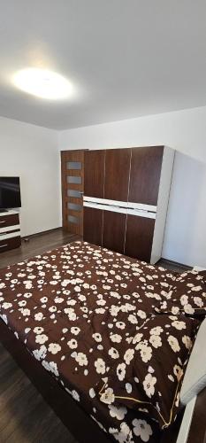 ein Schlafzimmer mit einem Bett mit einer braunen und weißen Decke in der Unterkunft Spatios si calduros in Floreşti