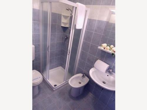 een badkamer met een douche, een toilet en een wastafel bij Enjoy poolside comfort - Beahost Rentals in Bibione