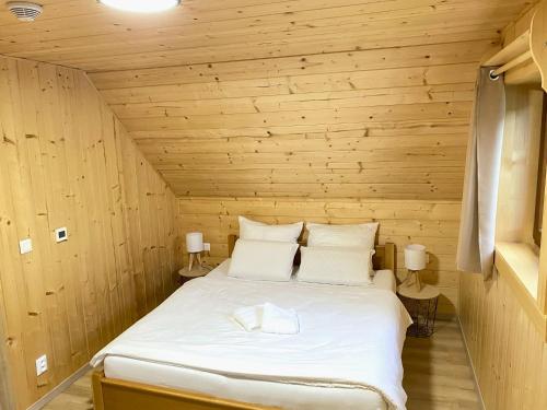 a bed in a room with a wooden wall at Chata Starý Mlyn in Habovka