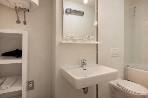 a white bathroom with a sink and a toilet at Adriatic Queen Residence in Split