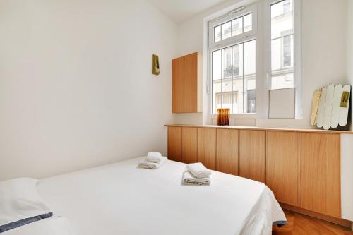 une chambre avec un lit blanc et une fenêtre dans l'établissement Belleville republique, à Paris