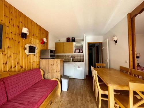 un salon avec un canapé rouge et une table en bois dans l'établissement Résidence Parc Aux Etoiles - C210PAE - APPARTEMENT 2 CHAMBRES AVEC BALCON MAE-8234, à Narreyroux