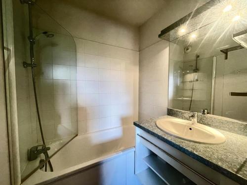 un bagno con lavandino e doccia con specchio di Résidence Parc Aux Etoiles - C210PAE - APPARTEMENT 2 CHAMBRES AVEC BALCON MAE-8234 a Narreyroux