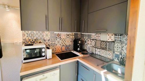 - une cuisine avec un comptoir, un four micro-ondes et un évier dans l'établissement Résidence Les Anémones - Chaleureux Appartement de montagne 4 pers MAE-1921, à Vallouise
