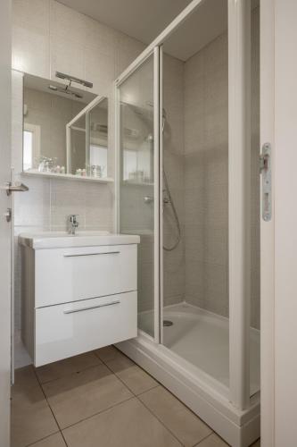 a white bathroom with a shower and a sink at Adriatic Queen Residence in Split
