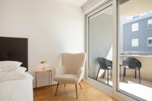 a bedroom with a bed and a chair and a window at Adriatic Queen Residence in Split