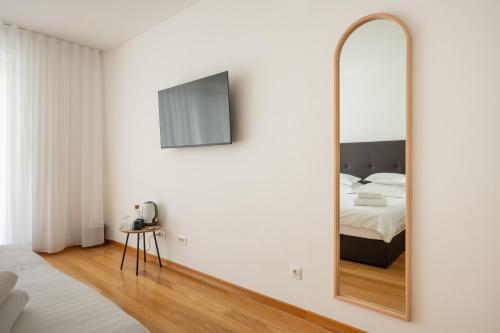 a bedroom with a mirror and a bed at Adriatic Queen Residence in Split