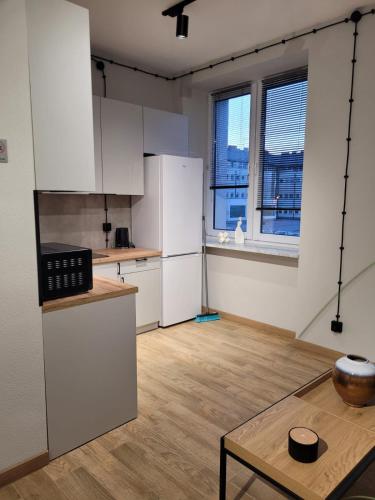 an empty kitchen with white cabinets and a table at Axo-Hostel 4 in Stalowa Wola