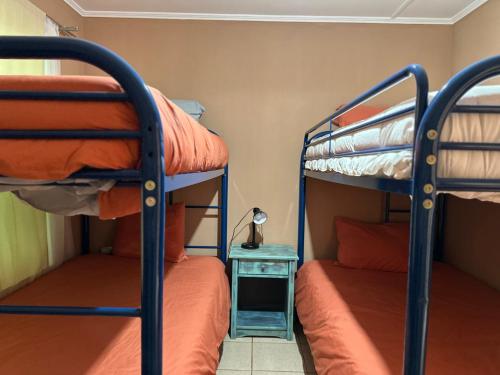 two bunk beds in a room with a table and a lamp at Casa Once in San Pedro de Atacama
