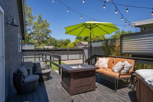 a patio with a couch and a table and an umbrella at Casa de Forest- Hot tub and Pet Friendly! in Templeton