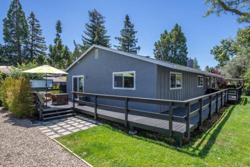 a gray tiny house with a large deck at Casa de Forest- Hot tub and Pet Friendly! in Templeton